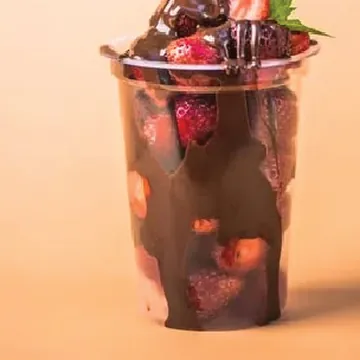 Strawberries layered with chocolate in a cup